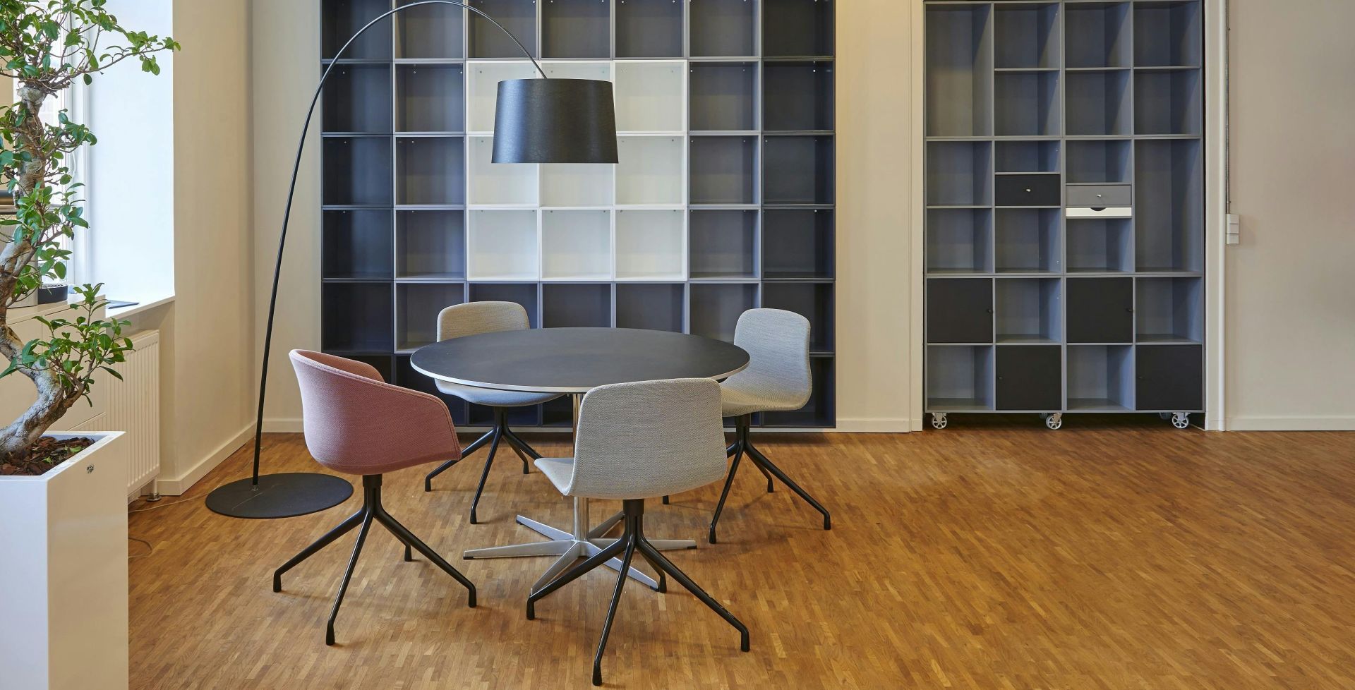 Bright and stylish office space with contemporary furniture and open shelving.